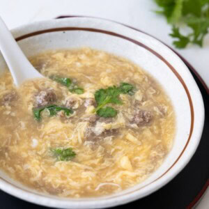 West lake beef soup with cilantro in a white soup bowl.