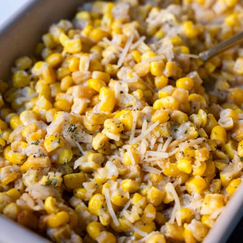 Creamy baked parmesan cheese corn with extra parmesan cheese sprinkled on top.