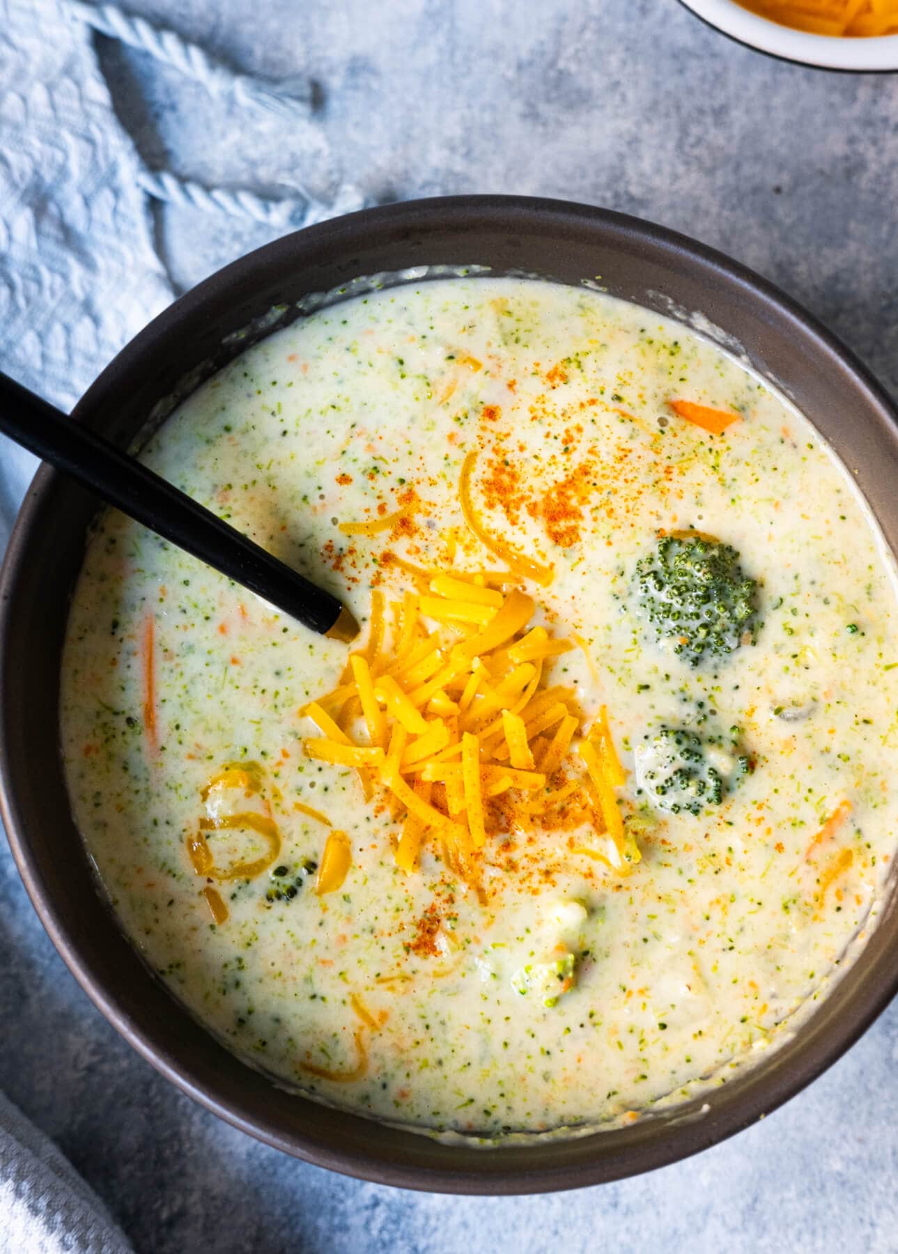 Broccoli cheddar soup in a bowl with a spoon. 
