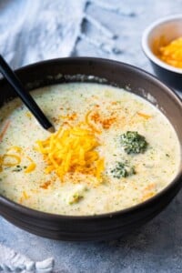 Creamy broccoli cheddar soup with extra cheddar cheese on top.