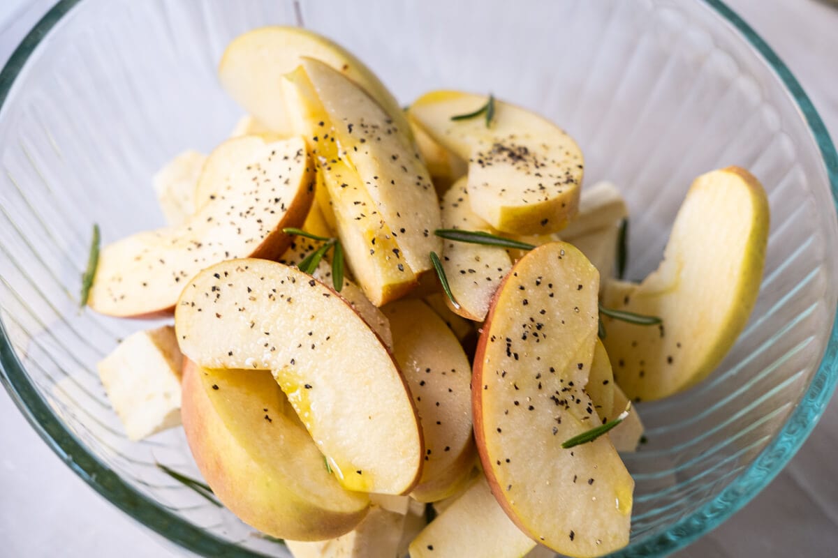 Toss well apple slices and sweet potatoes in olive oil and rosemary. 
