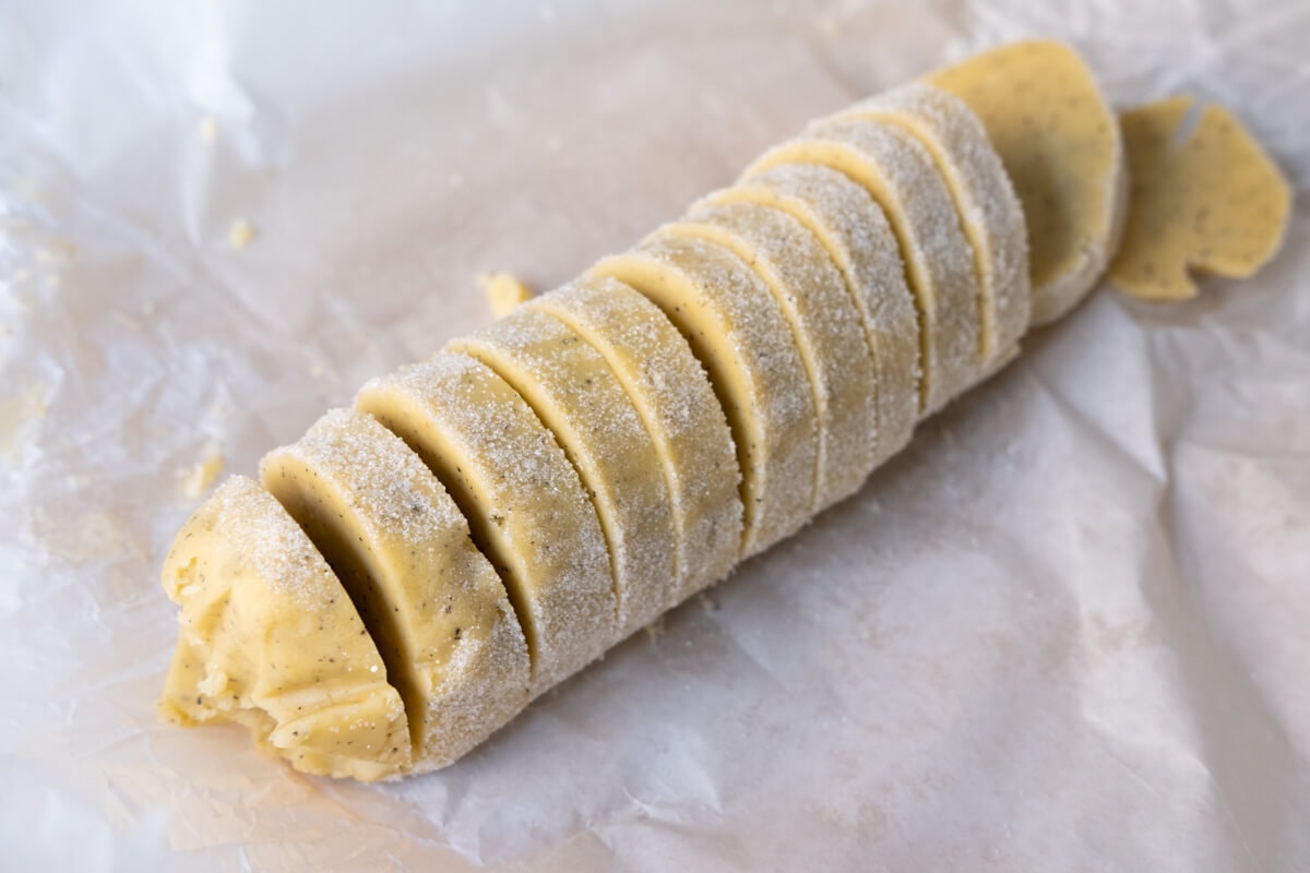 Cookie dough sliced on baking paper. 