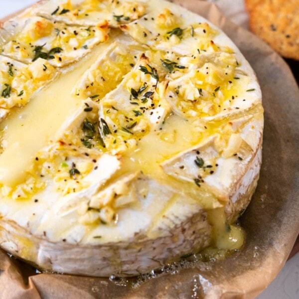 Garlic butter baked brie with fresh thyme leaves on top.