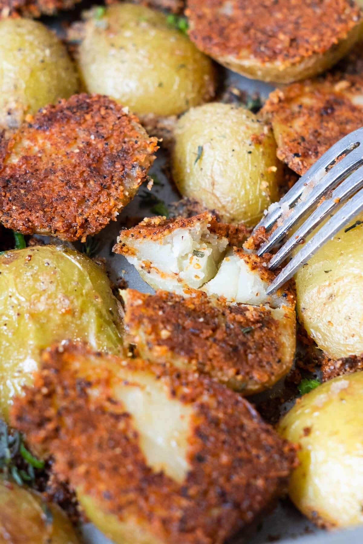 Fork tender parmesan crusted potatoes in a baking tray. 
