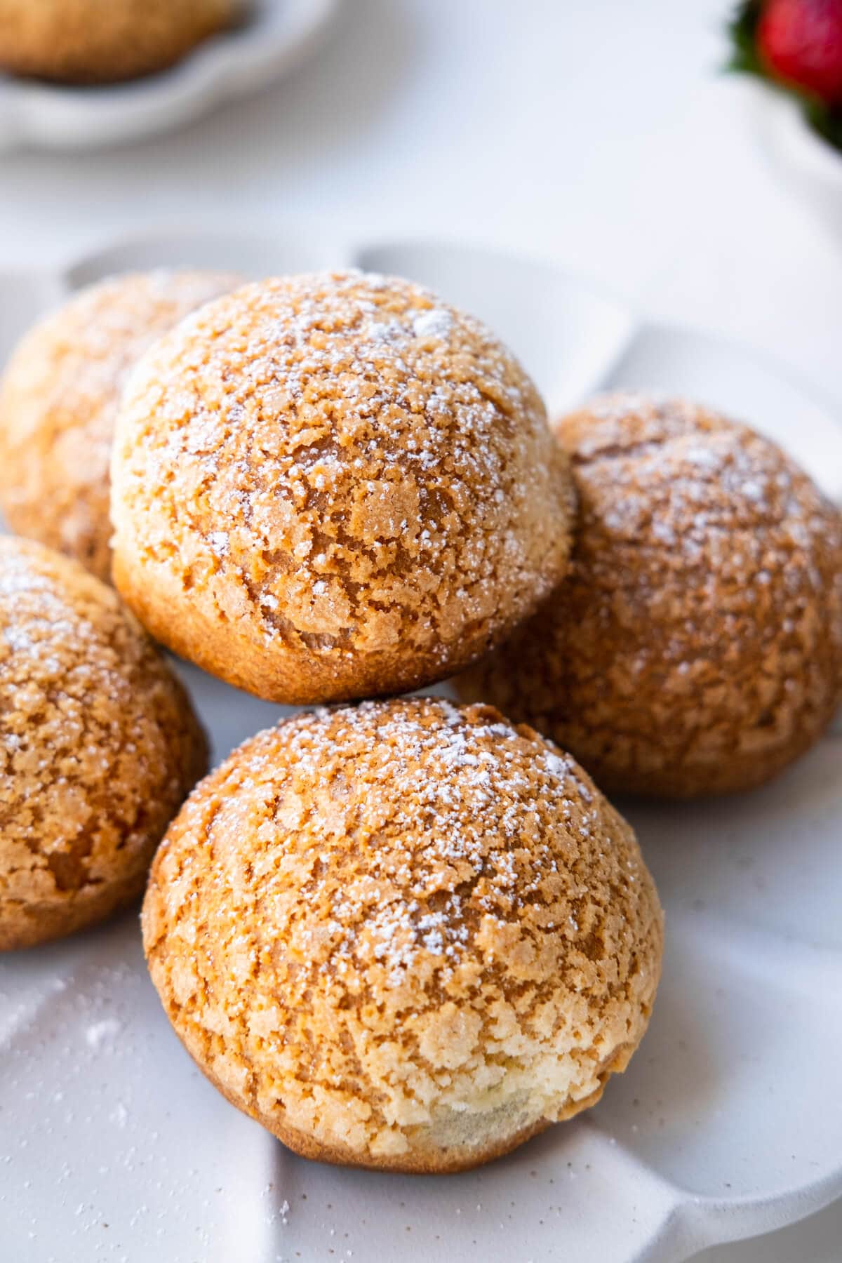 Round crispy golden brown pastry filled with cream and sprinkled with dusting powdered sugar. 