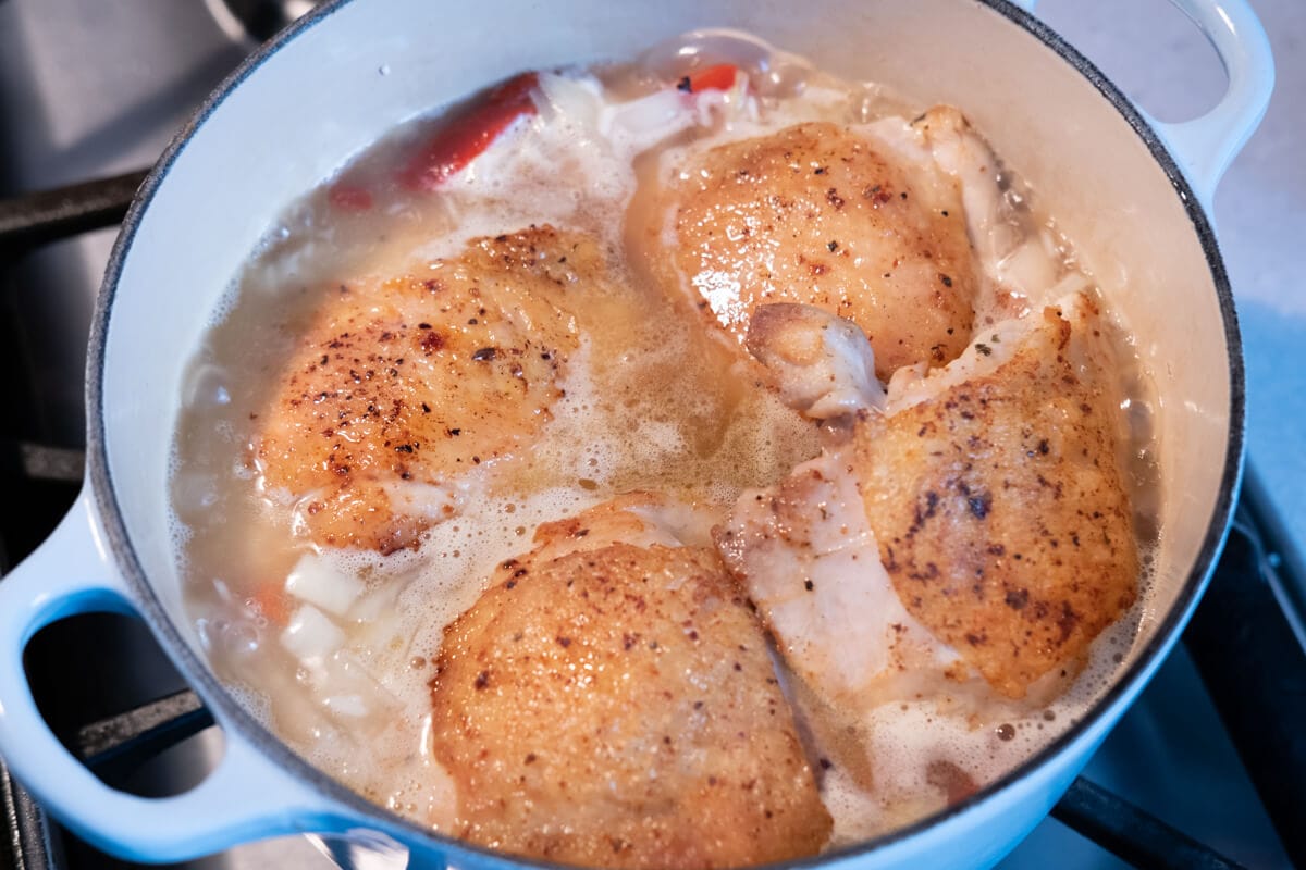 Seared chicken thighs cooked in a pot. 