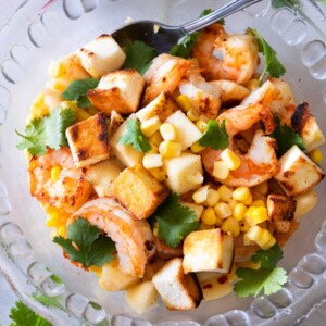 Prawn salad with peach and served with crumbled bread on top.