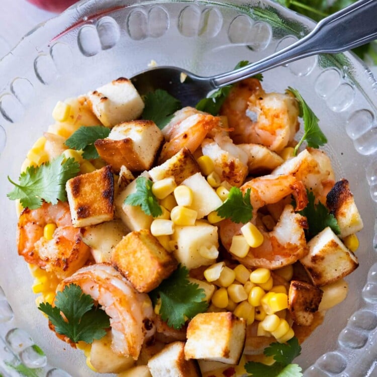 Prawn salad with peach and has cilantro and peach aside.