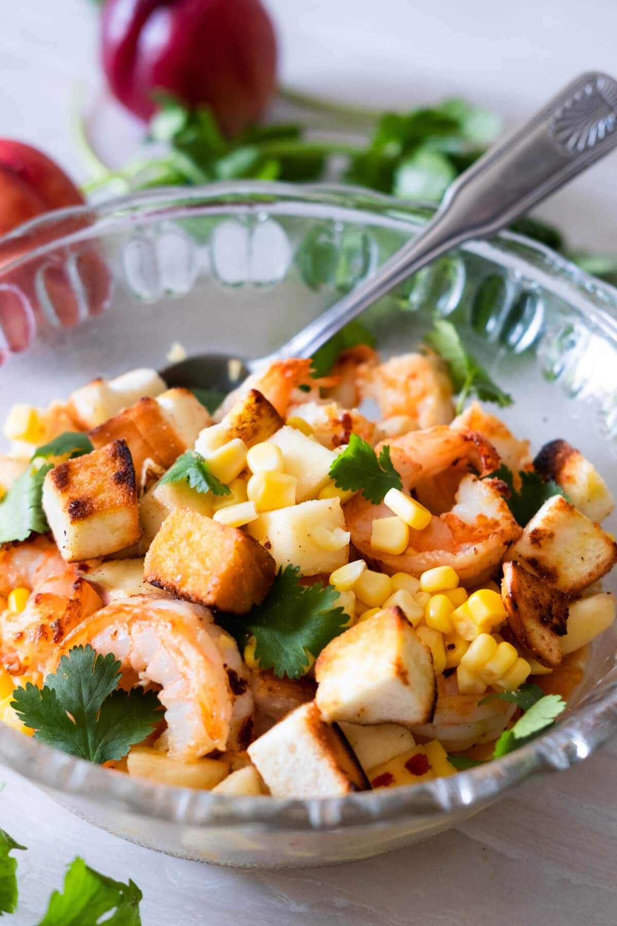 Prawn salad with peach topped with sweet corn, crountons and cilantro leaves. 