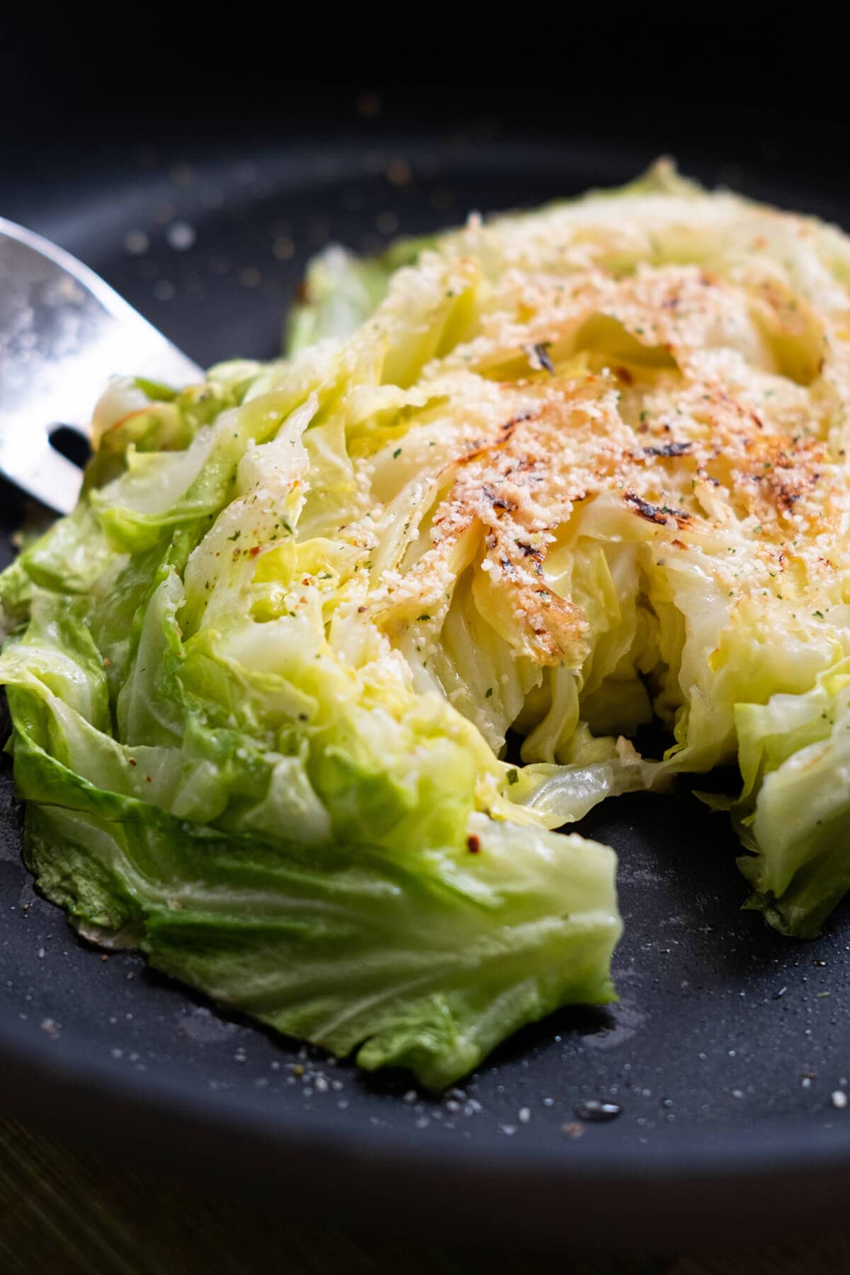 Tender cabbage steaks seared in a pan. 