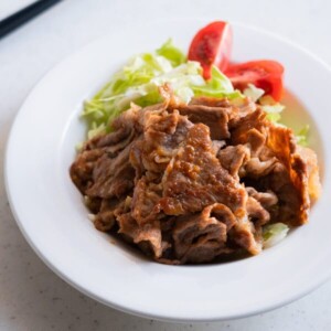 Japanese ginger pork served with lettuce and tomato.