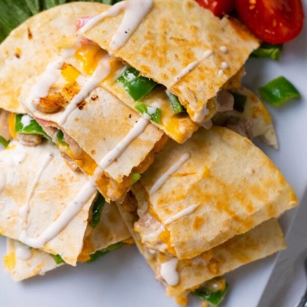 Chicken and bacon quesadilla served on lettuce and tomatoes aside.