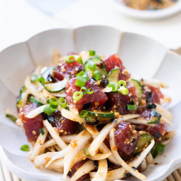 Easy and delicious poke bowl comes with yellow onion and cucumber in a savory sauce.