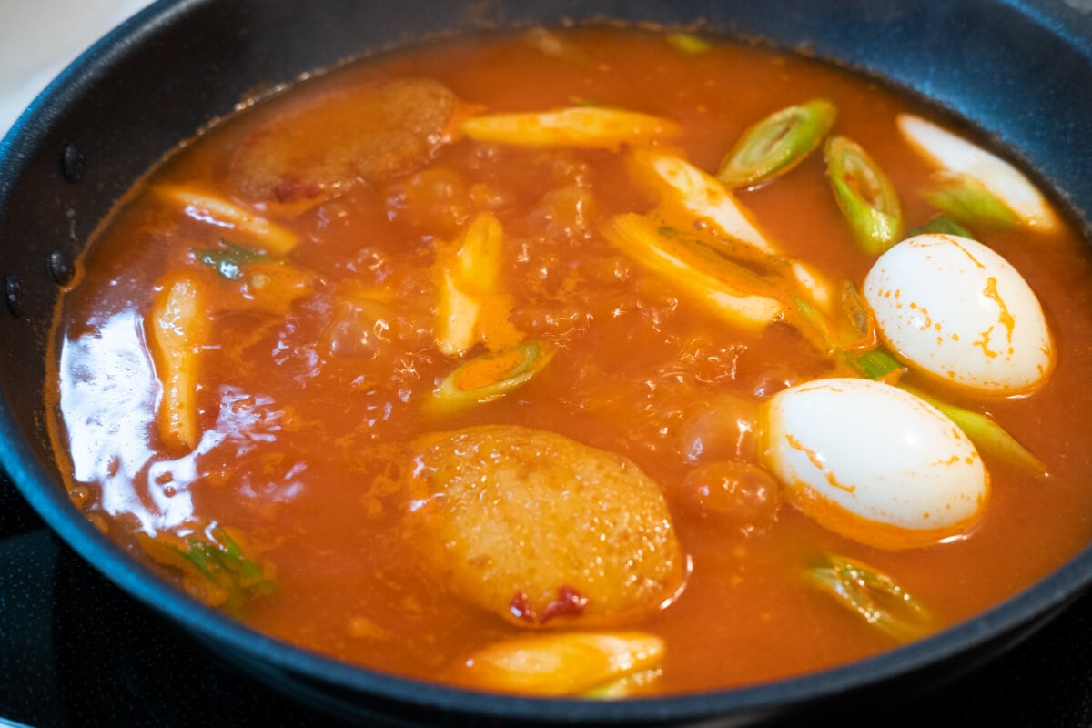 Rice cake, boiled eggs,and fish cakes cooked with mixed gochujang sauce in the pan. 
