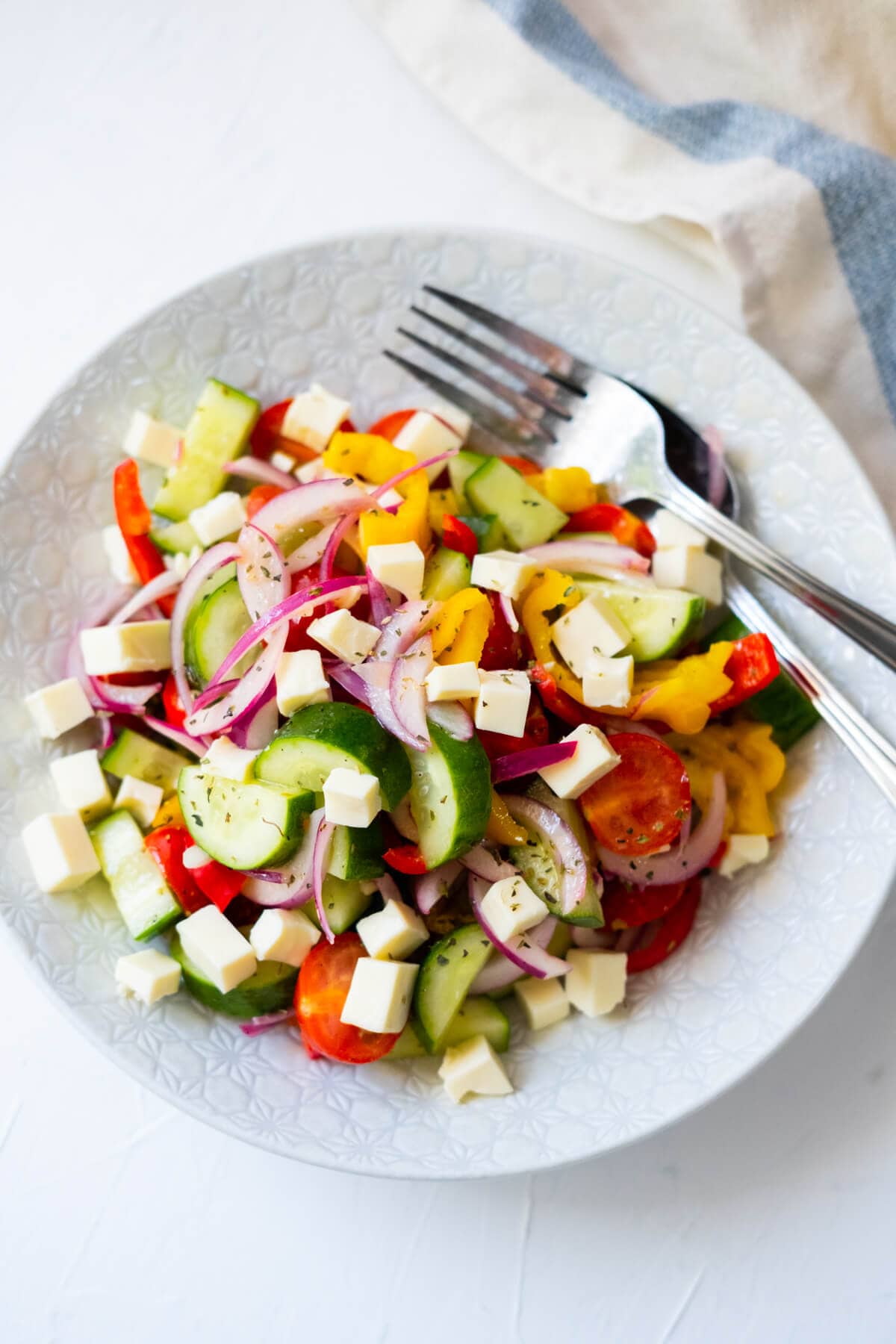 Refreshing Greek salad made with cucumber, bell peppers, red onion, and cherry tomatoes. 