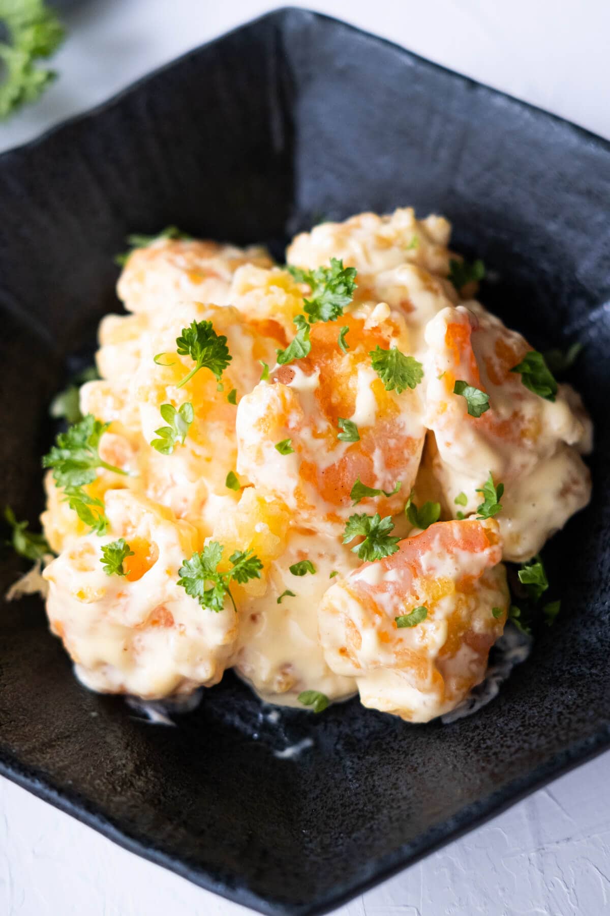 Creamy and flavorful mustard mayo shrimp in a black plate. 