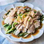 Easy and quick bang bang chicken in a plate with cucumber on the bottom.