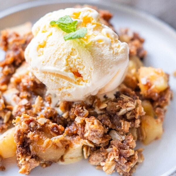 Warm apple crisp served with vanilla ice cream on top.