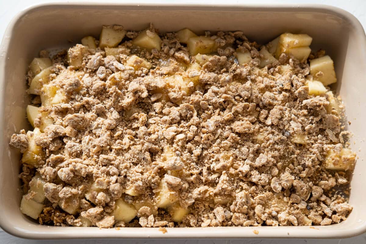 Add flour mixture to the baking tray and layer with chopped apple in between. 