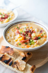 Easy, delicious cheesy ham chowder served in a bowl with pita bread on the side.