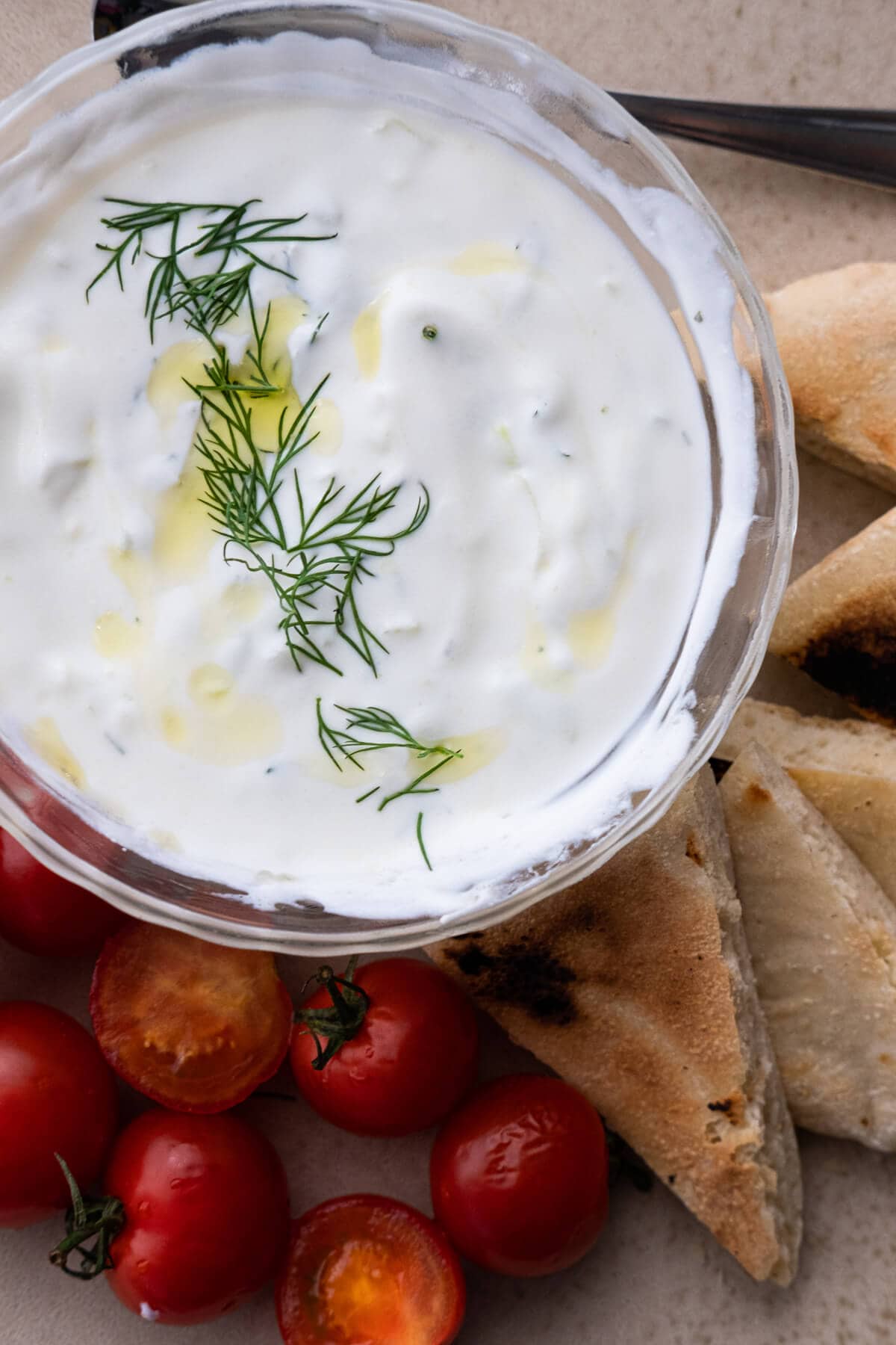 Creamy classic tzatziki sauce topped with fresh dill and olive oil drizzle. 