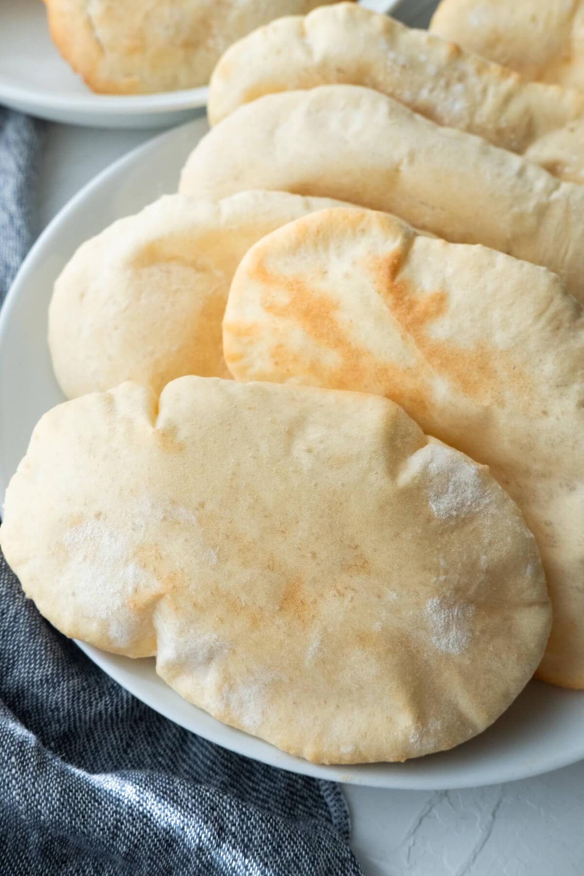 Puffy pita bread on a shallow plate.