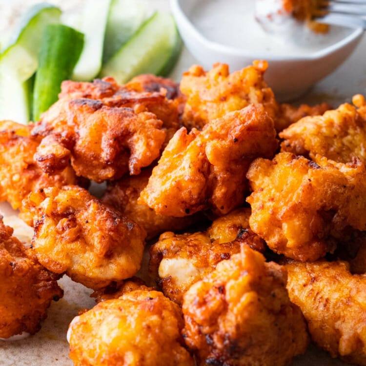 Buffalo chicken bites are served with ranch dressing and fresh cucumber.