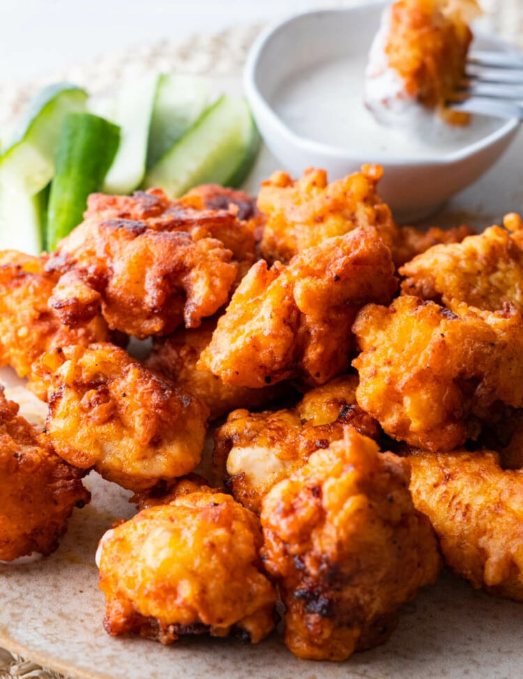 Buffalo chicken bites are served with ranch dressing and fresh cucumber.