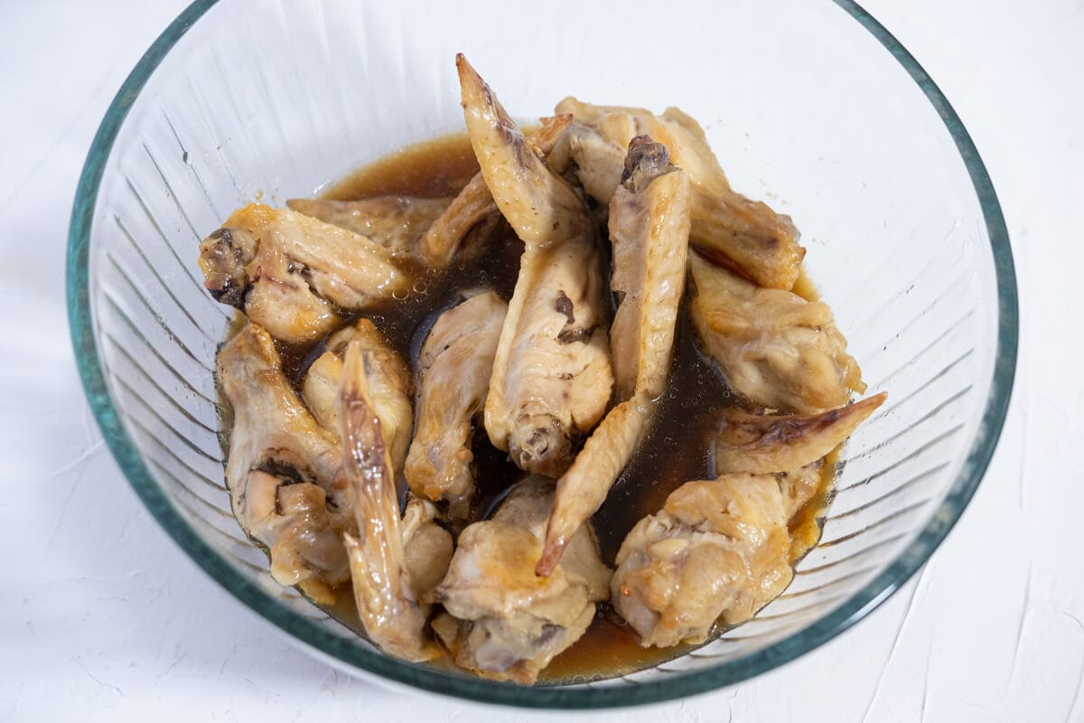 Chicken wings soaked with cola sauce in a large bowl. 