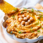 Creamy hummus topped with chickpeas, paprika, green onion and drizzle with olive oil.