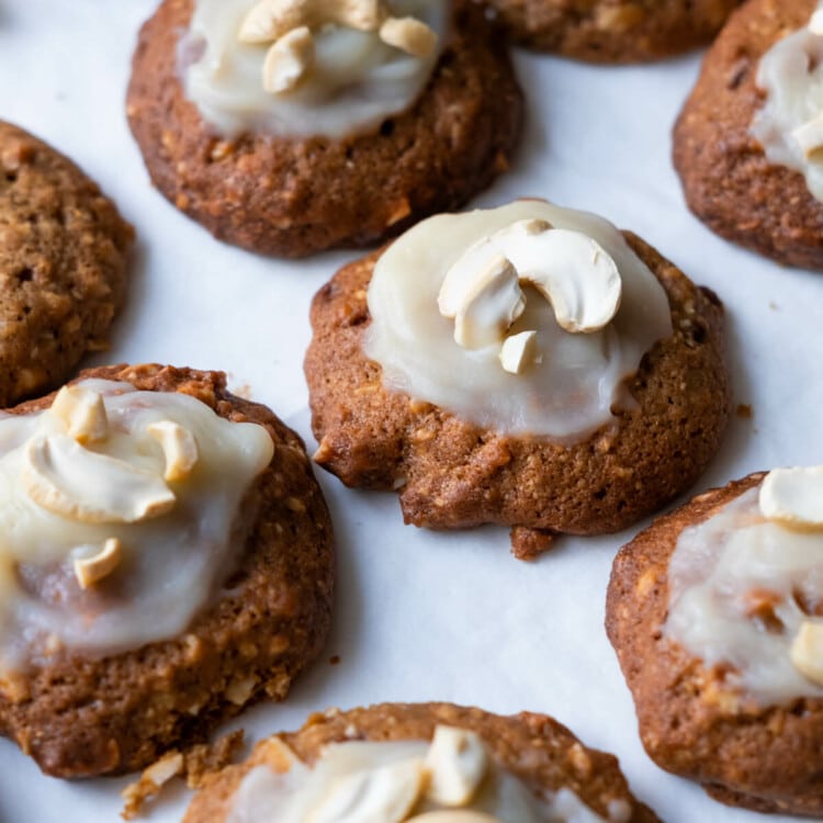 Frosting cashew cookies with cashew on top.