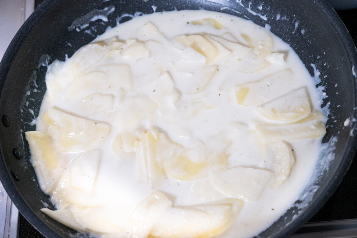 Cook the sliced potatoes in a white creamy sauce. 