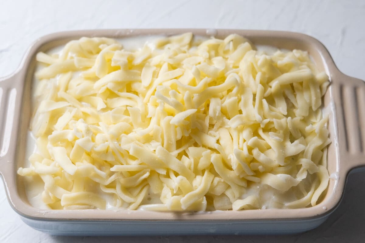 Transfer the cooked potato slices and white sauce to a baking dish and top with mozzarella cheese. 