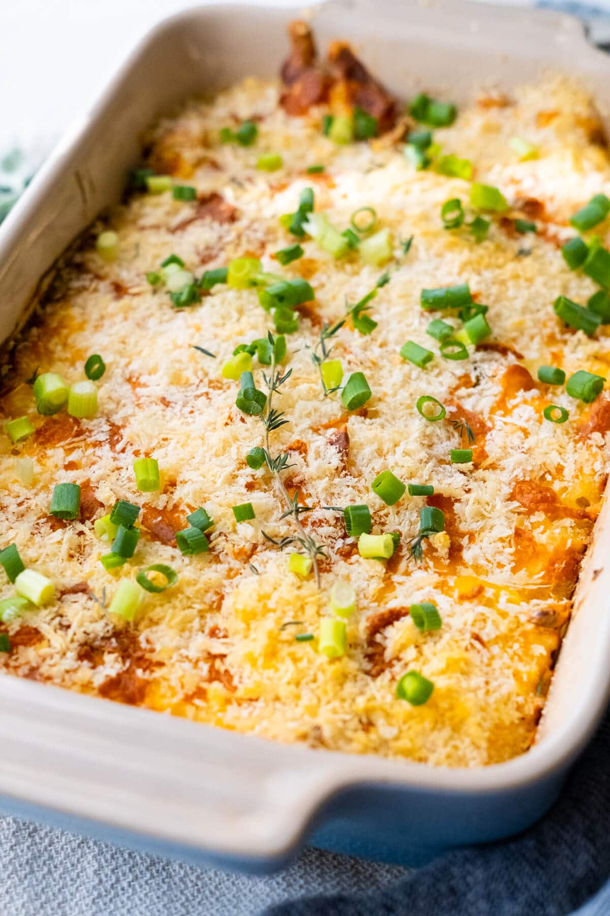 Delicious corn casserole with golden crisp top and melted cheese in a baking dish. 