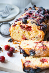 Dusting the cranberry cake with confectioner's sugar and fresh cranberries on the side.