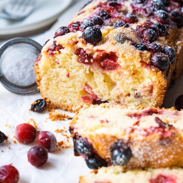 Dusting the cranberry cake with confectioner's sugar and fresh cranberries on the side.