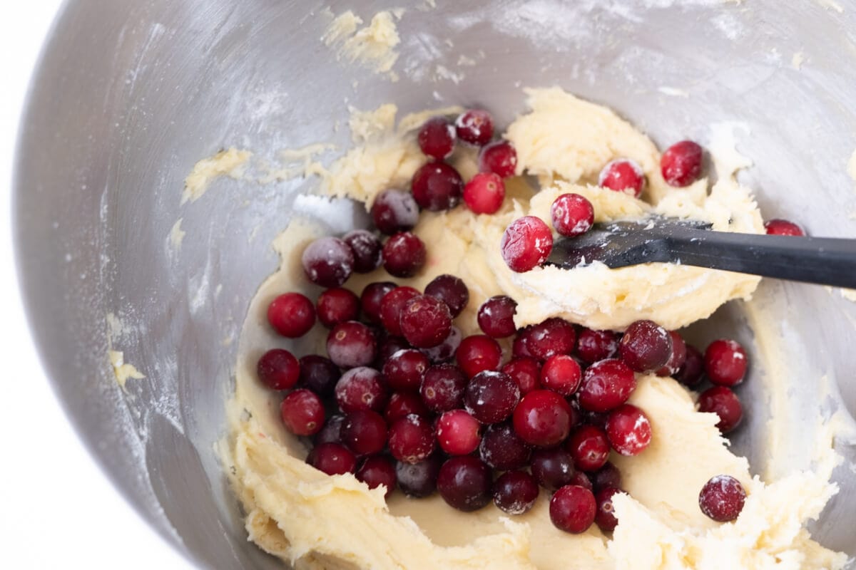 Frozen cranberries mixed with the batter in a mixing bowl. 