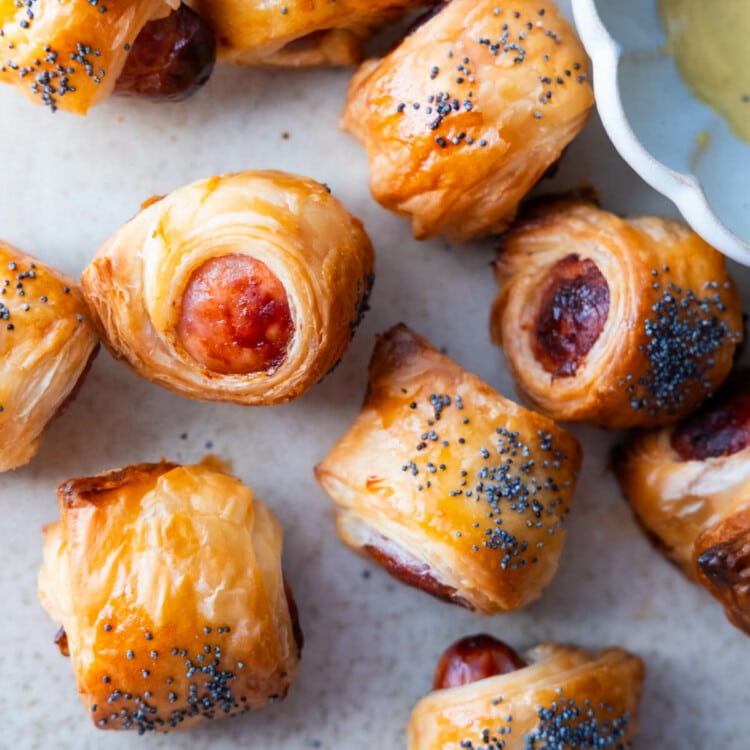 Pig in blankets with poppy seeds on top.
