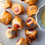 Pigs in blankets served with mustard sauce.