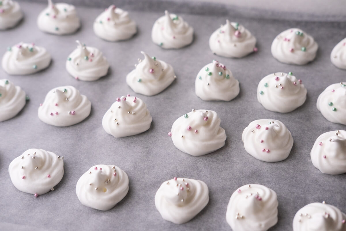 Pipe meringue onto a baking sheet lined with parchment paper and top with sprinkles. 