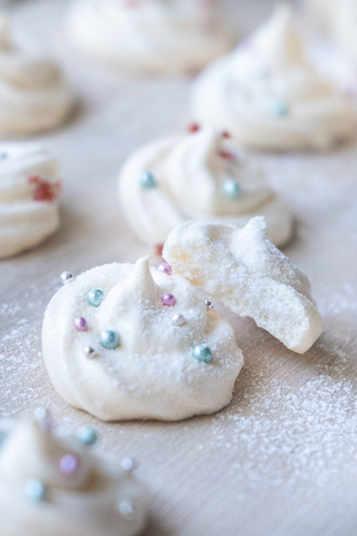 Crisp vanilla meringue cookies with confectioner's sugar dusting on top. 