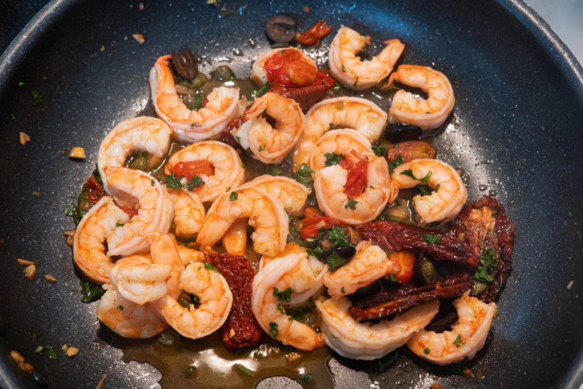Add shrimp to skillet and cook to pink, and stir in chopped parsley. 