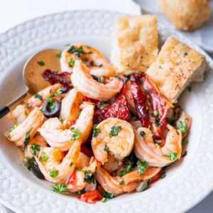 Mediterranean olive and shrimp served in a bowl served with focaccia.