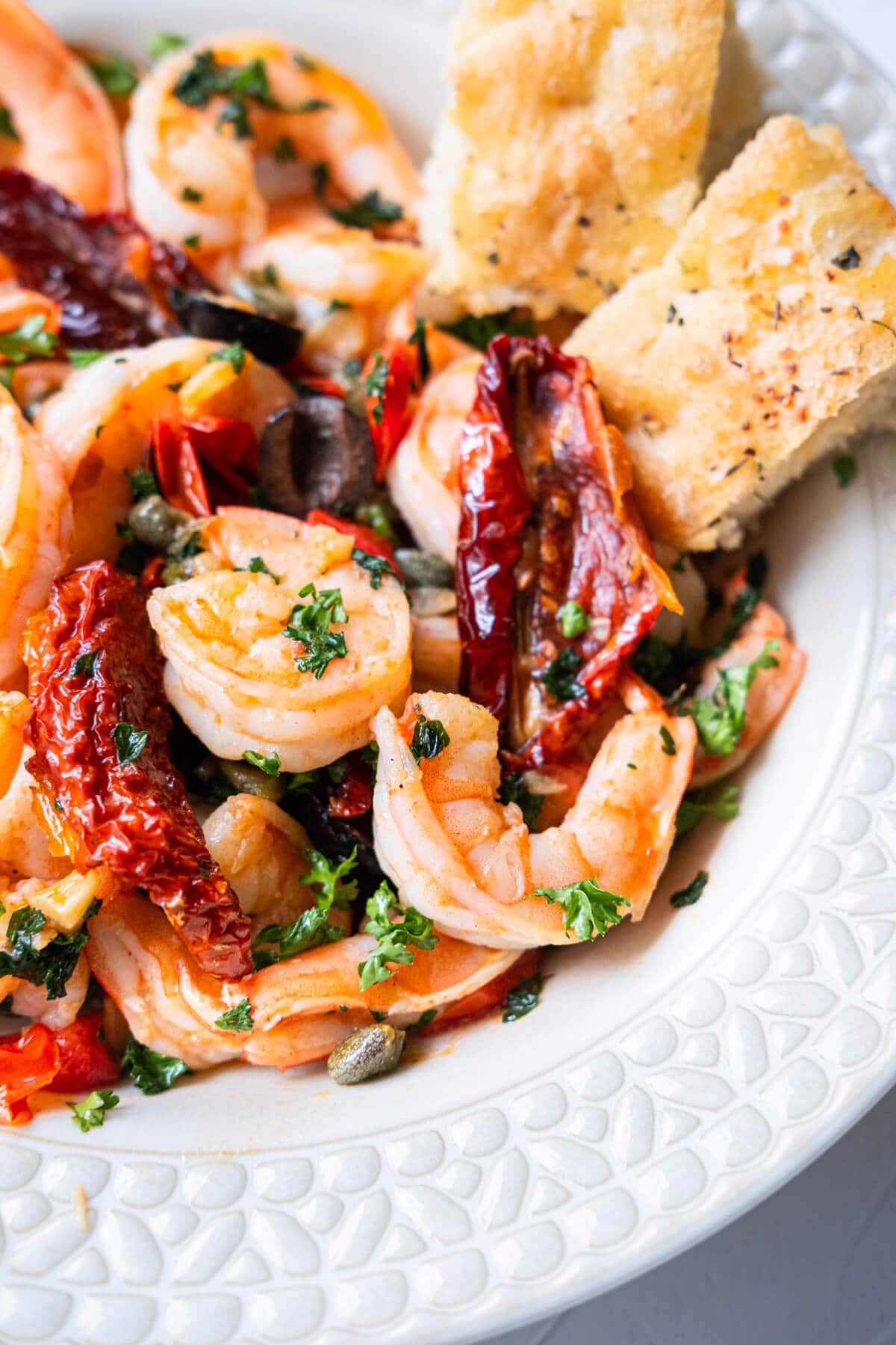 Large shrimp with olive oil and sun dried tomato sauce, and two slices of focaccia. 