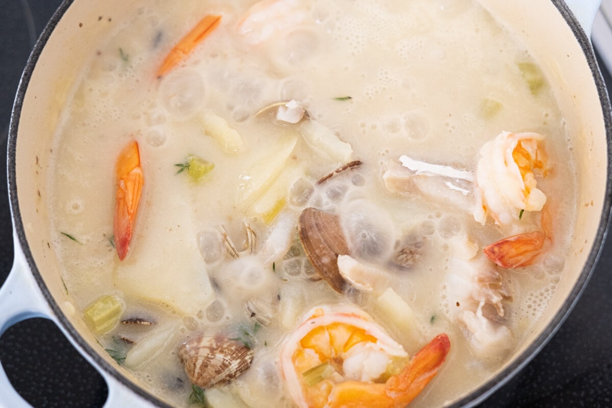 Add seafood to the chowder, and cook. 