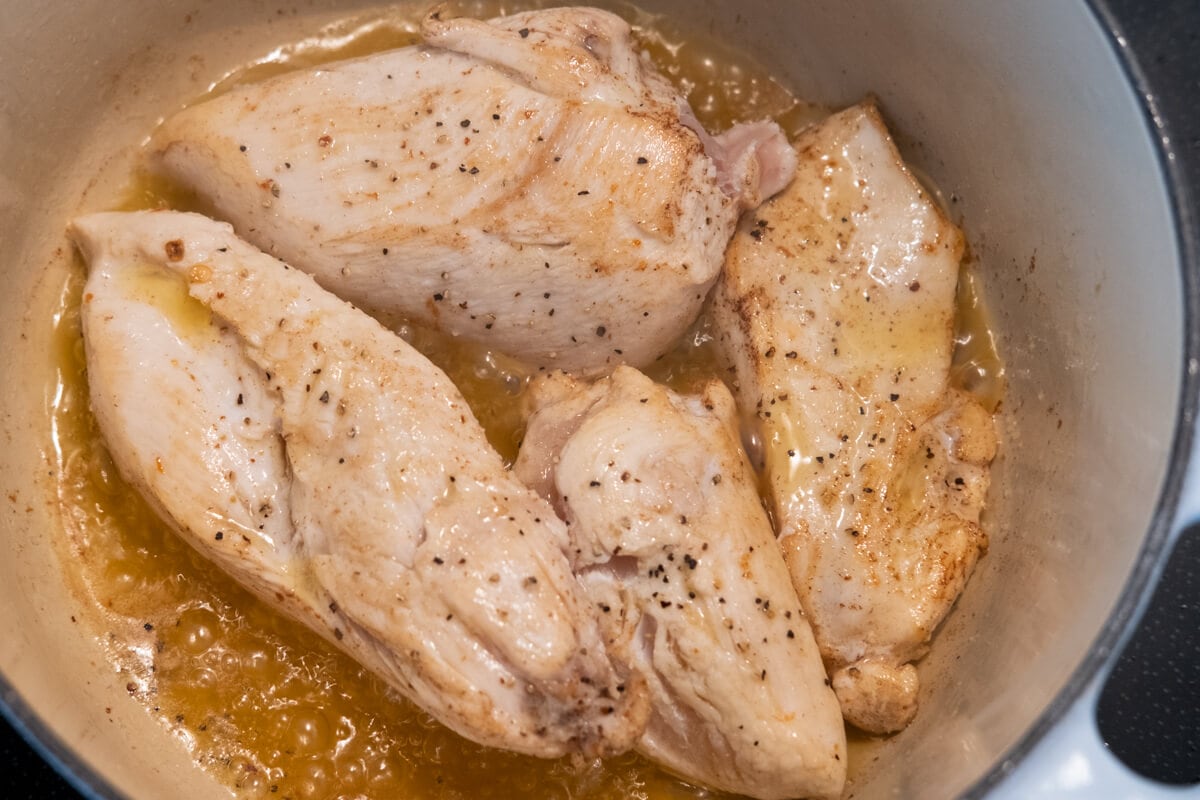 Sear the chicken breast slices in a heavy-bottom pot until both sides are golden brown. 