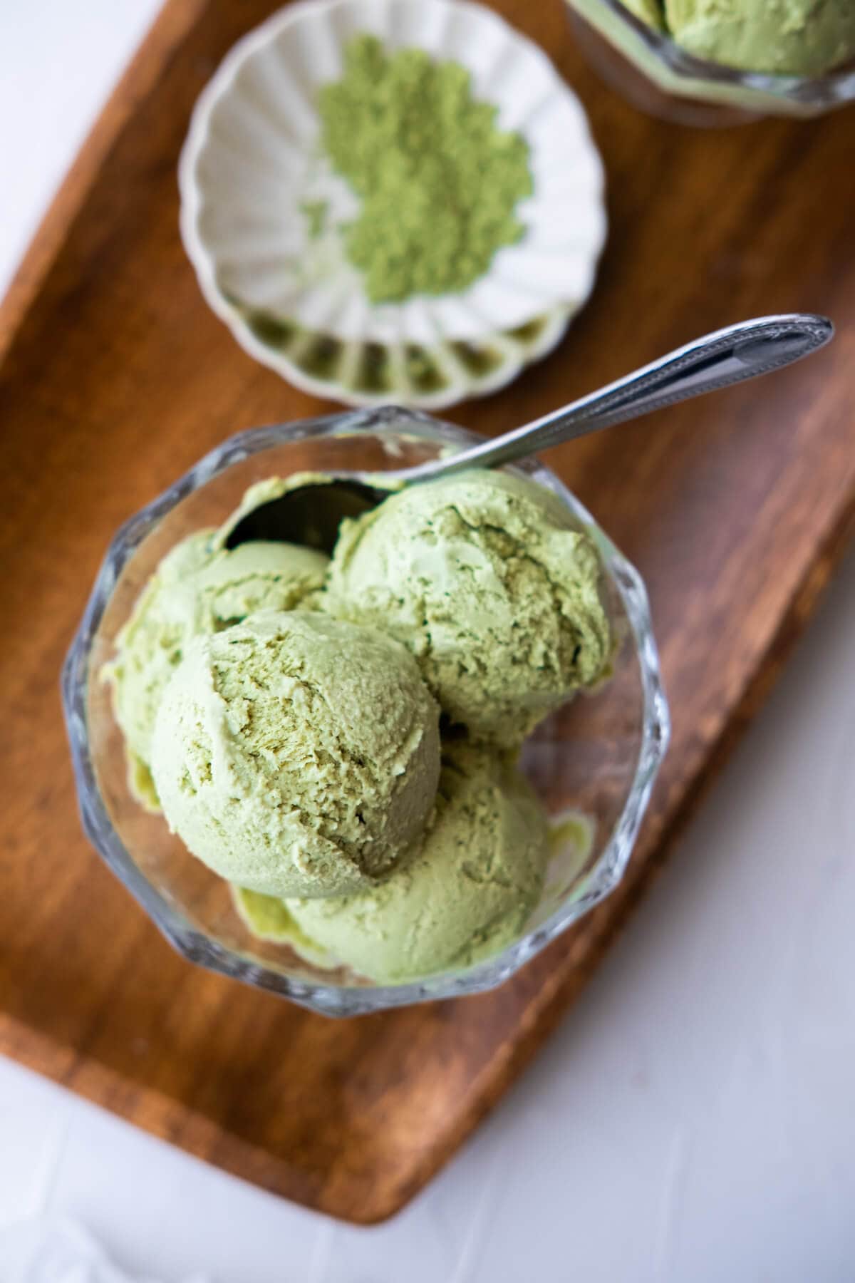 Creamy ice cream with vibrant match green color and served aside with match powder. 