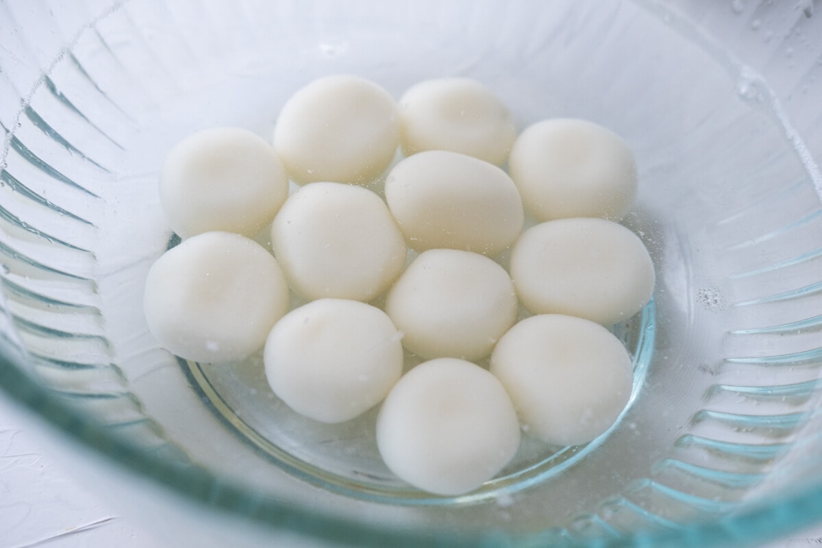 Cooked glutinous rice flour dumplings soaked in water to cool. 