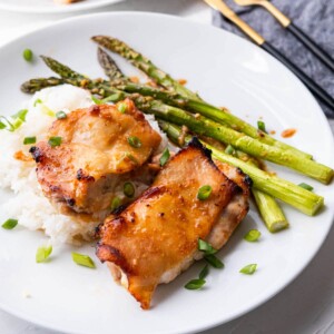 Miso-honey chicken thighs alongside asparagus.