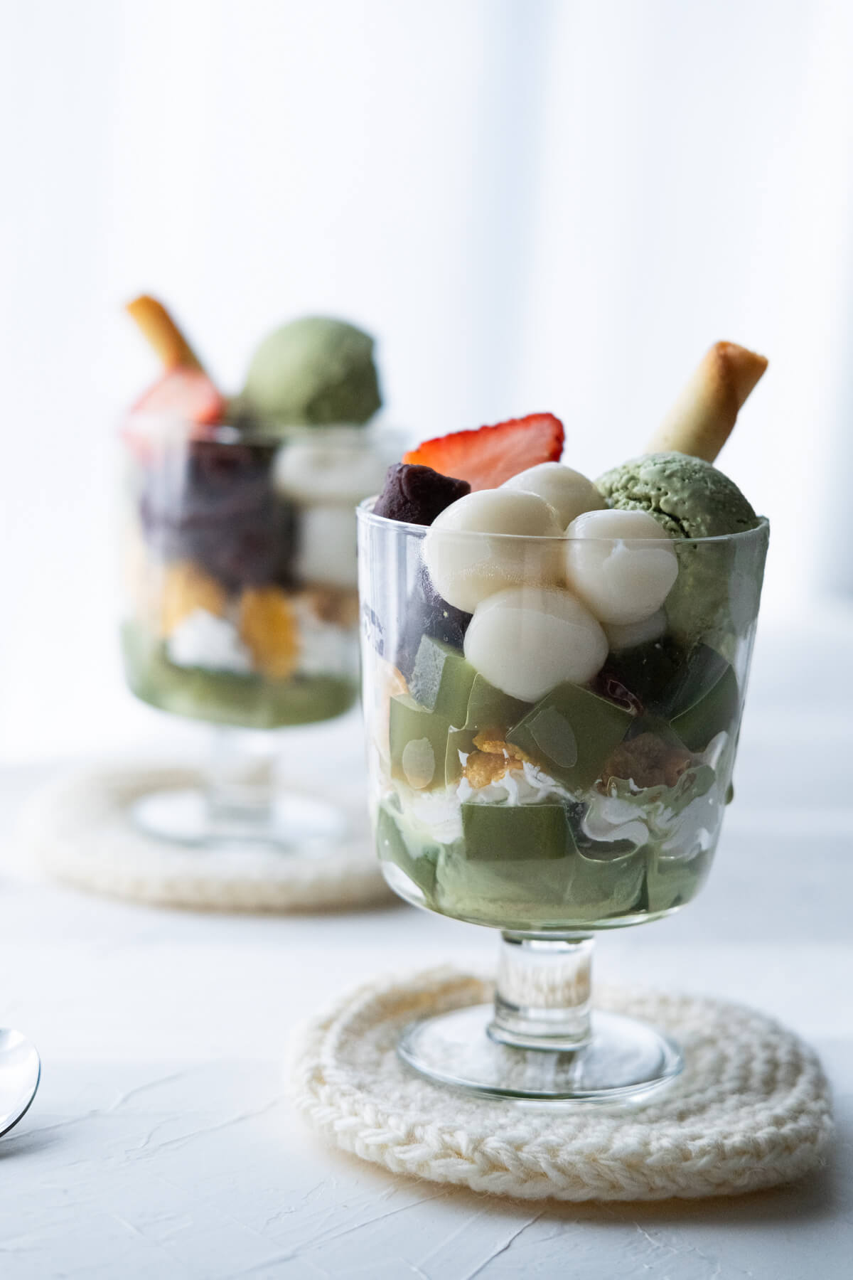 The layers of matcha parfait shows cleanly throughout the glass cup. 